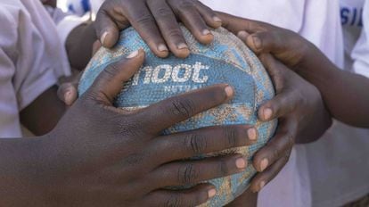 Las jugadoras de Mthulu, ganadoras del campeonato, sujetan en balón después del partido, en Malawi.