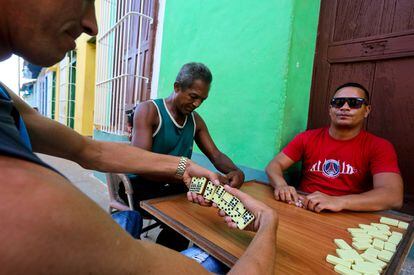 Unos vecinos juegan al dominó en las calles de Trinidad.