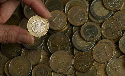 Una persona mostra una moneda d'euro.