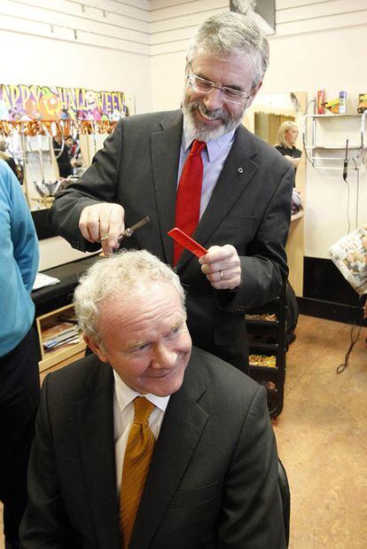Gerry Adams, presidente del Sinn Féin, finge cortar el pelo al candidato de su partido, Martin McGuinness, ayer en Dublín.