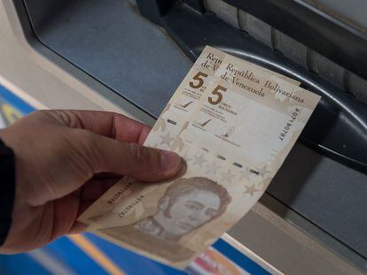 Una persona saca dos billetes de 5 bolívares digitales, la nueva divisa venezolana, este viernes en Caracas.