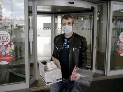 El taxista Rafael Contreras posa con adaptadores para máscaras de bucear y con mascarillas en la entrada del Hospital Infanta Leonor en Leganés.