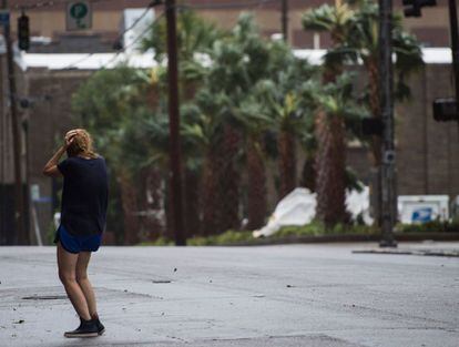 Una mujer se cubre de los vientos y la fuerte lluvia del huracán Florence en Wilmington, Carolina del Norte.