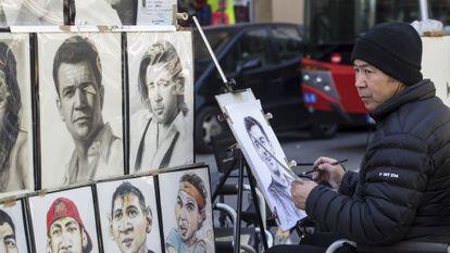 Un dibujante de la Rambla realiza un retrato 