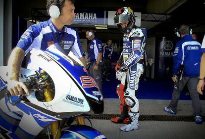 Jorge Lorenzo observa el estado de los neumáticos de su moto en el 'box' de Yamaha.