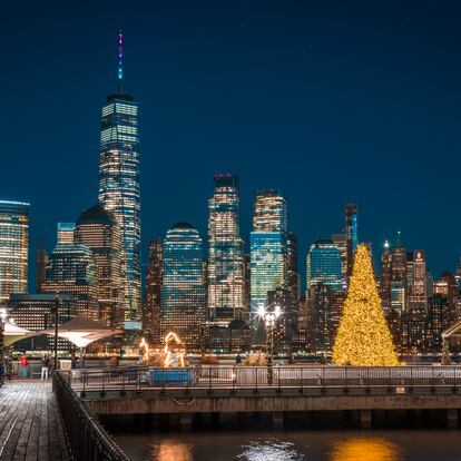 Vista de Manhattan desde Nueva Jersey, con un árbol navideño iluminado en primer plano.