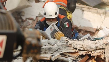 Un miembro del Ejército mexicano observa un libro encontrado bajo los escombros de un edificio durante las tareas de rescate, en Ciudad de México.