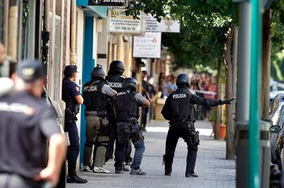 Varios policiales ante la sucursal bancaria del barrio valenciano de Benicalap antes de detener al atracador y liberar a los tres rehenes.