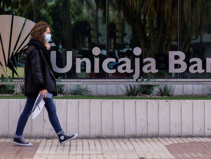 Una mujer pasa ante la sede de Unicaja en Málaga. 