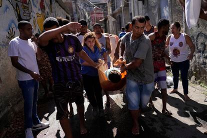 Ciudadanos trasladan un cuerpo, en la favela Alemão, en Rio de Janeiro, este jueves.