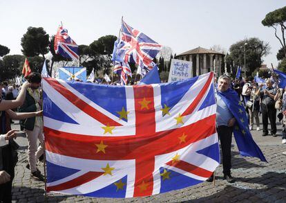 Un grupo de ciudadanos británicos exhiben una bandera de la 'Union Jack' mientras se preparan para participar en una manifestación en apoyo a la Unión Europea, en Roma.