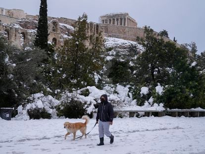 Un hombre pasa con su perro por los alrededores de la Acrópolis, este martes en Atenas.