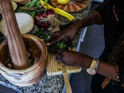 Mayra Gastro prepara una receta en su cocina haciendo un majado en el mortero, instrumento imprescindible en las cocinas africanas.