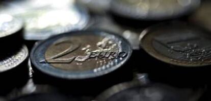 Detalle de varias monedas de euro sobre una mesa.