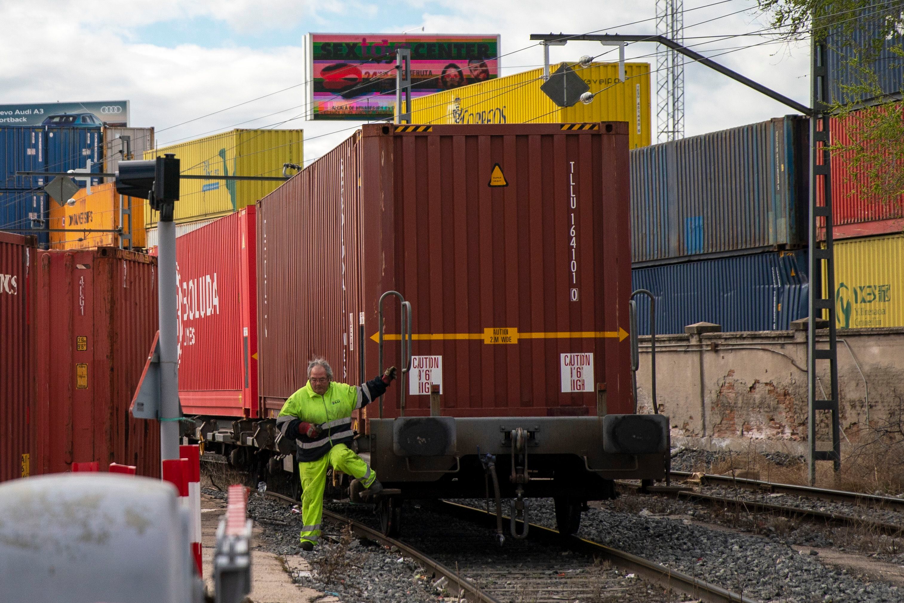 Un trabajador ferroviario, este viernes, acompañando a un tren que entra en la terminal de mercancías de Albroñigal, en Madrid.