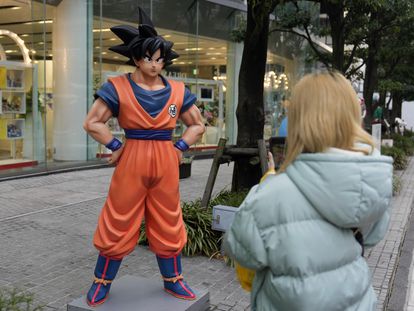 Un transeúnte tomaba fotografías de una estatua de Son Goku, personaje de 'Dragon Ball' creado por el artista de manga japonés Akira Toriyama, frente a Bandai Co. en Tokio, Japón, este viernes.