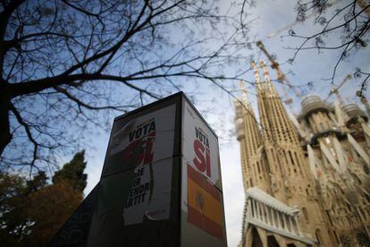 Cartell amb la llegenda "Vota Sí" en una cabina de telèfon enfront de la Sagrada Família de Barcelona.