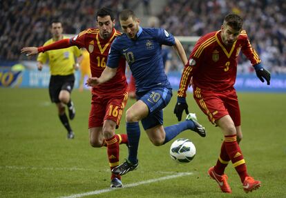 Karim Benzema (en el centro) controla el balón ante la presencia de Sergio Busquets (a la izquierda) y Gerard Piqué, durante el partido clasificatorio para el Mundial de Brasil 2014 entre las selecciones de Francia y España, disputado en el estadio de Saint Denis, cerca de París, en 2013.