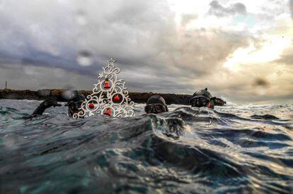 Buceadores posan con un árbol de navidad antes de sumergirse para colocarlo en el fondo del mar, en la costa de la ciudad portuaria del norte de Líbano (Tripoli).