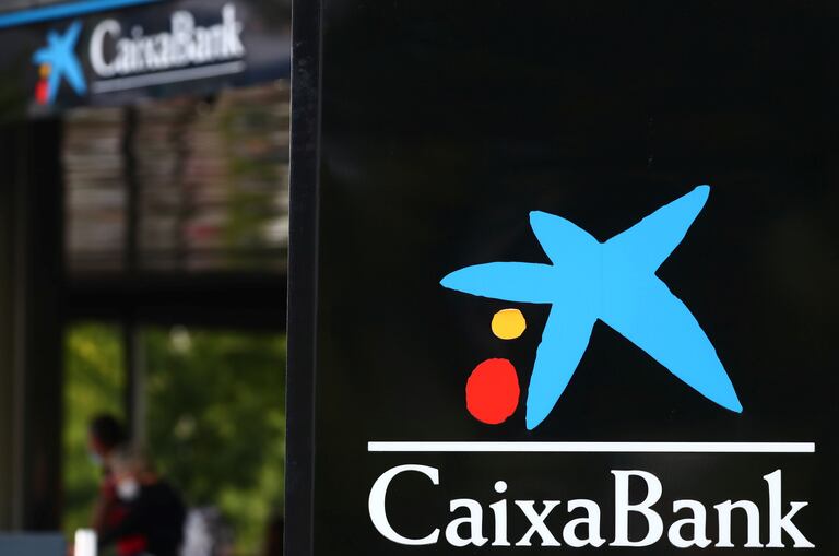 El logo de CaixaBank reflejado en una oficina de Madrid. REUTERS/Sergio Pérez