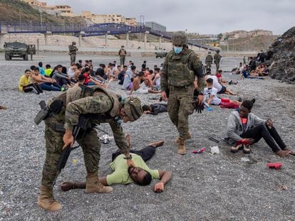 Un migrante es asistido por soldados del Ejército español en el enclave español de Ceuta, el pasado 8 de mayo.
