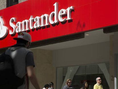 Varias personas pasan por delante de una oficina del Banco Santander.