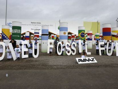 Niños muestran el mensaje "adieu Fossil Fuels" (adiós a los hidrocarburos) durante la Conferencia sobre el Cambio Climático de París (Francia).