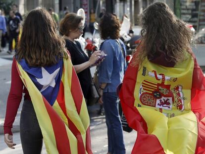 Dos personas con dos banderas distintas caminando juntas.