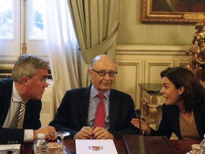 El ministro de Hacienda, Crist&oacute;bal Montoro, flanqueado por la vicepresidenta del Gobierno, Soraya S&aacute;enz de Santamar&iacute;a, y el secretario de Estado de Hacienda, Jos&eacute; Enrique Fern&aacute;ndez de Moya. efe