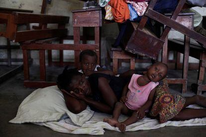 Una dona amb dos dels seus fills refugiats en una escola esperen que passi l'huracà, s'estima que 9.000 persones hauran de ser col·locats en llars temporals.