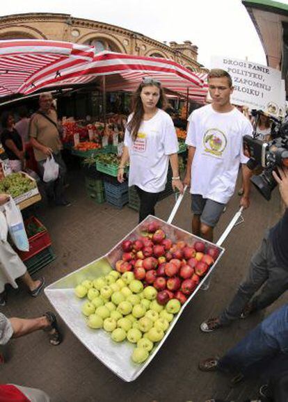 Dos jóvenes promocionan fruta polaca en Varsovia, en agosto.