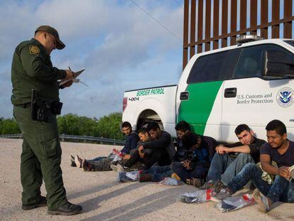 Un agente de la Patrulla Fronteriza detiene a un grupo de inmigrantes ilegales en la frontera entre México y Estados Unidos. 