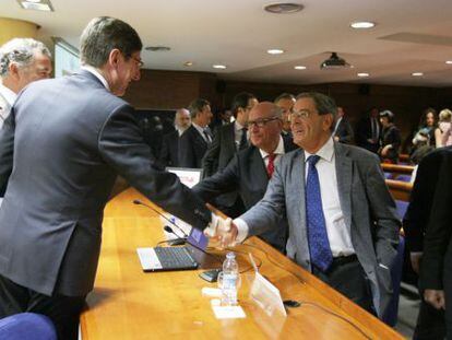 El presidente de Bankia, José Ignacio Goirigolzarri, saluda al expresidente de Kutxabank, Mario Fernández.