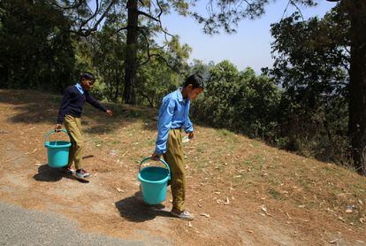 Two children carry water home from school near Sal village in Champawat district. 