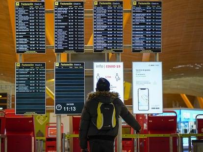 Un pasajero en el panel de salidas del aeropuerto de Barajas (Madrid), en diciembre.