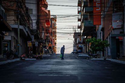 Un hombre con mascarilla cruza una calle vacía en Asunción (Paraguay). El Gobierno insistió este jueves en el "QuedateEnCasa", el lema que insta a la ciudadanía a restringir la sociabilidad y la movilidad en Semana Santa, en el marco de la cuarentena impuesta en ese periodo y ante una curva de contagios que tiene saturado el sistema de salud pública.