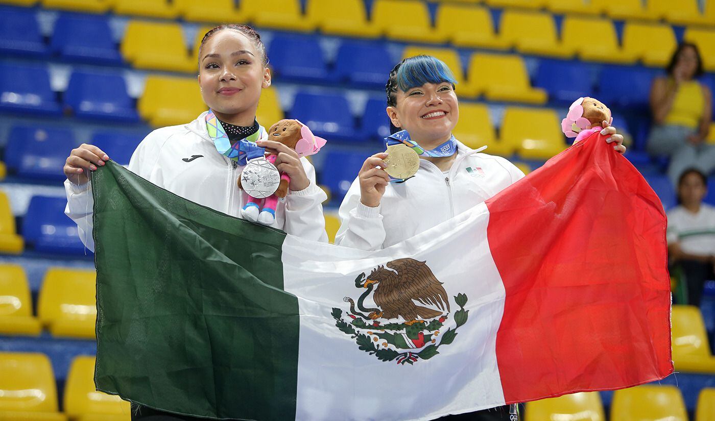 Las gimnastas Natalia Escalera y Alexa Moreno, sostienen sus medallas de plata y oro en la prueba de piso. 