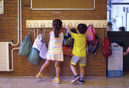 Dos niños hacen cuelgan sus mochilas en la Escola Catalonia de Barcelona. 