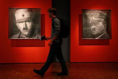 Un hombre delante de fotografías del dictador Adolfo Hitler.