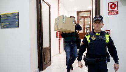 Un agent porta una caixa de les oficines del PP a València dimarts.