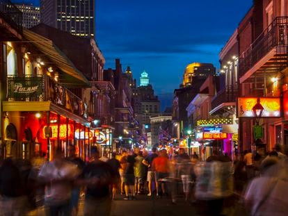 Viandantes paseando por la calle de Bourbon, repleta de bares y clubs en Nueva Orleans .