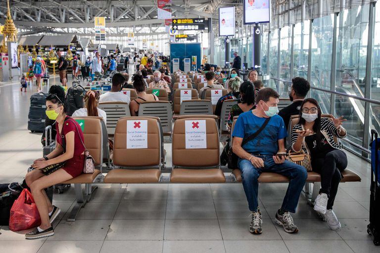 Viajeros llevando máscaras en el aeropuerto de Babkok y respetando la distancia de seguridad que indican los carteles, el 25 de marzo del 2020.
