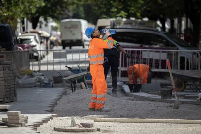 Un trabajador de la construcción bebía agua el fin de semana para combatir el calor en una calle del centro de Valencia.