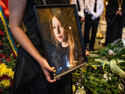 Una mujer sostiene una imagen de Victoria Amelina, durante el funeral de la escritora.