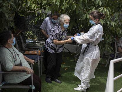 Una cuidadora atén una dona gran a la residència geriàtrica Gravi, a Polinyà.