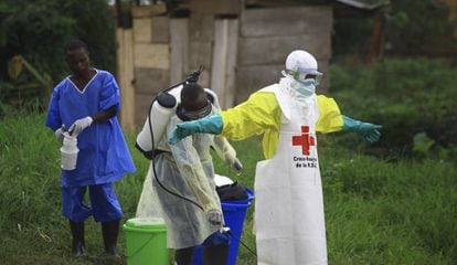 Un trabajador sanitario pulveriza con desinfectante a un colega en Beni, en Congo.