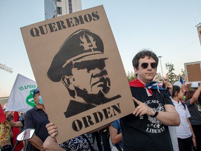 Un hombre sostiene un cartel con el rostro de Augusto Pinochet en una protesta a favor de la policía el 6 de abril 2023 en Santiago, Chile.