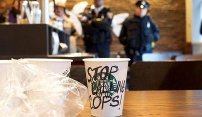 Vaso de caf&eacute; con las palabras &ldquo;Dejad de llamar a los polis&rdquo;, mientras la polic&iacute;a vigila las protestas dentro de una tienda de Starbucks en Filadelfia.