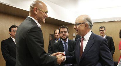 El consejero catalán de Exteriores, Raül Romeva, saluda al ministro de Hacienda, Cristóbal Montoro, este viernes.