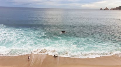 Un surfero en playa Monumento, cerca del cabo San Lucas. Al fondo de la imagen, a la derecha, se observa El Arco.